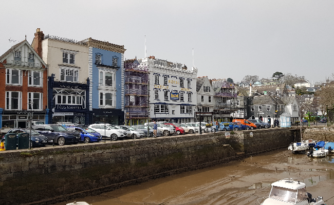 Shops situated near the water with cars parked in front